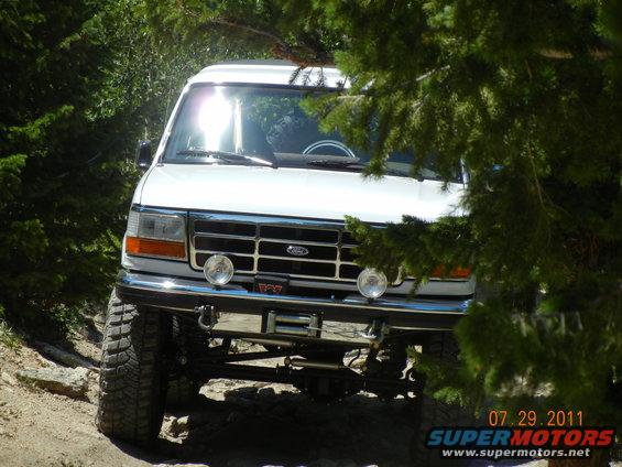 White 1996 Ford Bronco front view, modified for off-road with large tires and winch