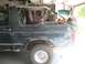1995 Ford Bronco - Side view of a dark green 1995 Ford Bronco with its top removed and visible body damage.
