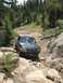 1995 Ford Bronco - This blue 1995 Ford Bronco tackles a challenging off-road path, demonstrating its capability on terrain.