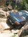 1995 Ford Bronco - This vehicle is navigating a difficult rocky terrain, with its front tire deep in a crevice.