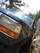1995 Ford Bronco - This dark green SUV is stuck between two large rocks on a trail.