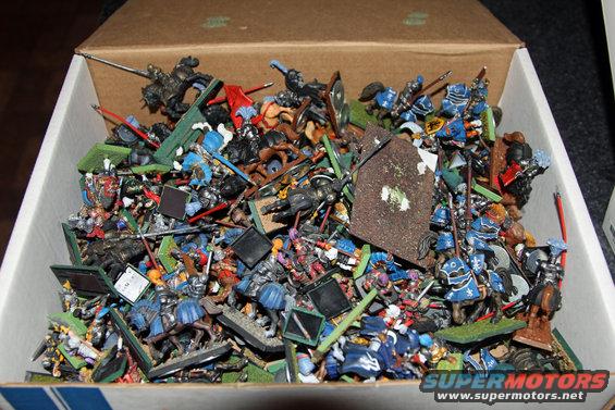 Box of assorted miniature medieval figurines, some on horseback, with weapons and shields