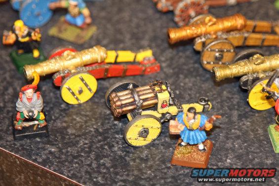 Collection of miniature cannons and figures on a textured surface