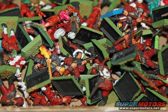 Pile of miniature soldiers in red and green bases, some with rifles