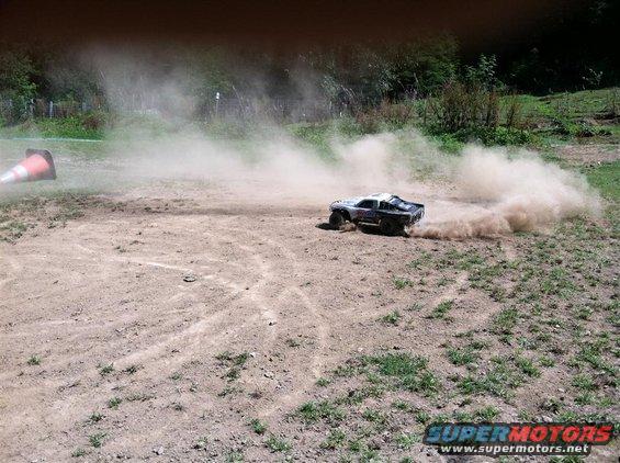 Remote control truck drifting, kicking up dust on a dirt track