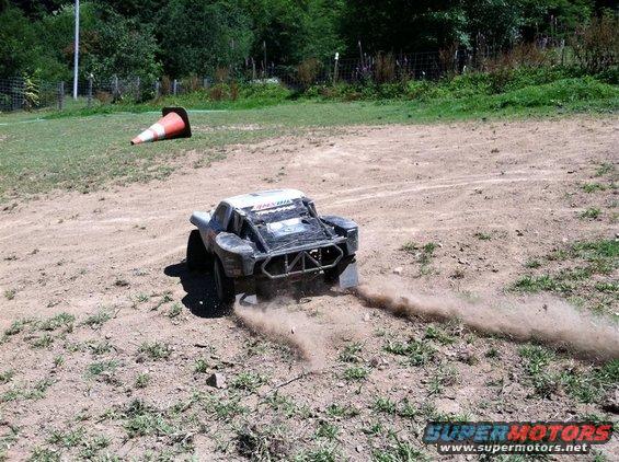 Remote control short course truck kicking up dust on a dirt track