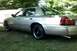 2000 Mercury Grand Marquis - A gold sedan is parked on a grassy lawn with trees providing shade.