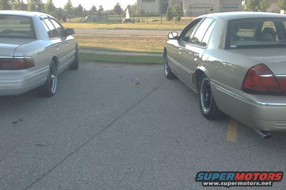 Two 2000 Mercury Grand Marquis sedans parked side-by-side on asphalt