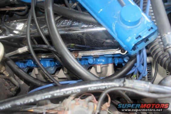 Close-up of engine bay showing blue painted exhaust manifold and wiring