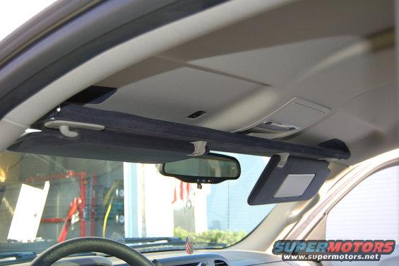 Interior shot of a vehicle's overhead console and sun visors, with a rearview mirror visible