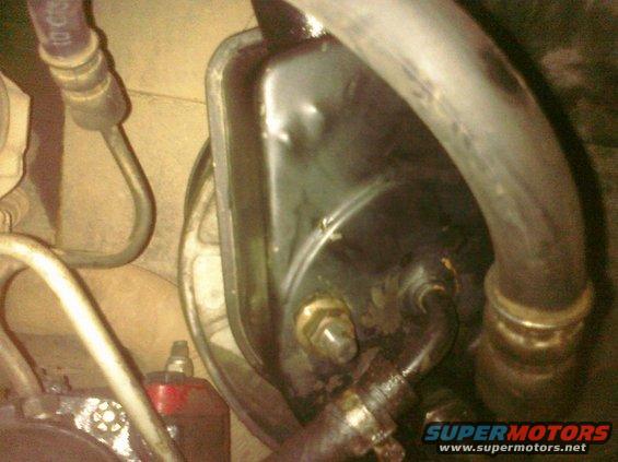 Close-up of a vehicle's power steering pump with hoses attached