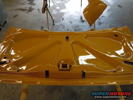 Underside of yellow car hood, freshly painted