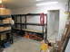1993 Ford F-250 - A cluttered garage scene with shelves filled with boxes and various tools, including jack stands and a ladder.