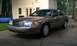 2007 Ford Crown Victoria - A tan 2007 Ford Crown Victoria is parked on a driveway in front of a house.