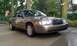 2007 Ford Crown Victoria - A 2007 Ford Crown Victoria is parked outside on a wet driveway with trees and an American flag in the background.