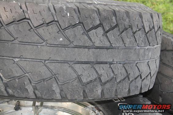 Tire tread detail, showing wear and a Supermotors.net watermark