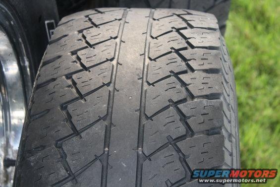 Close-up of a tire tread with a chrome rim visible on the left