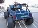 1985 Ford F-150 - A blue toy truck with "BIGFOOT 4X4" graphics is shown from the rear with large tires.