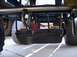 1985 Ford F-150 - The underside of a lawn mower deck is shown, with its exhaust pipe and rear wheels visible.