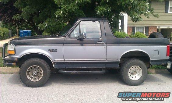 Side view of a 1995 Ford Bronco with two-tone paint and a spare tire in the bed