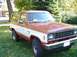 1984 Ford Bronco II - This two-tone Ford Bronco II is parked on a grassy lawn with trees in the background.