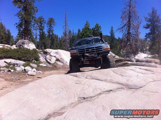 Ford Bronco climbing over rocks on a trail