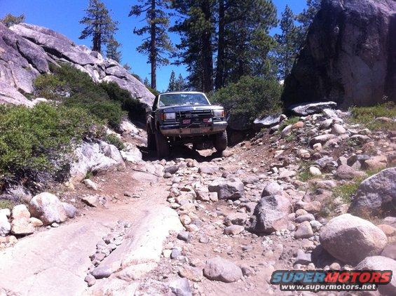 Dark gray Ford Bronco navigating a rocky, off-road trail