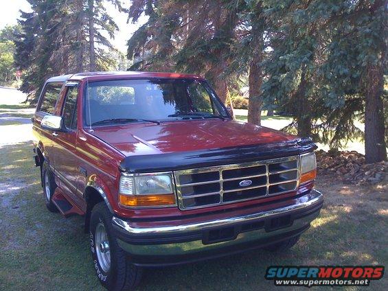 Red 1996 Ford Bronco front 3/4 view with chrome grille and side steps