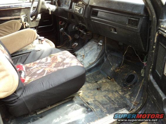 Interior of a dirty truck cab with camouflage seat covers and a cracked dashboard