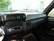 1986 Ford Bronco - The dashboard of a vehicle, an aftermarket stereo system and air vents, with a view of the exterior through the windshield.