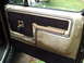 1986 Ford Bronco - The interior door panel shows wear and tear with a brown fabric insert and tan trim.