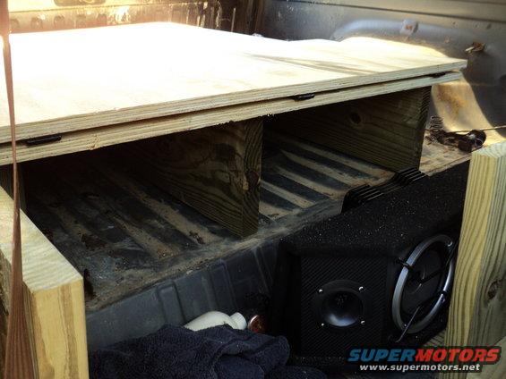 Truck bed with custom wooden platform and subwoofer
