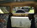 1986 Ford Bronco - View from inside a truck, looking out through the rear window at another vehicle and a spare tire.