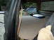 1986 Ford Bronco - Looking into the back of a vehicle, with a cooler and another SUV visible through the open door.