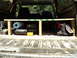 1986 Ford Bronco - The cargo area of a vehicle is organized with a wooden shelf holding various tools and supplies.