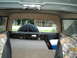 1986 Ford Bronco - The interior of the vehicle shows camouflage seat covers and a spare tire mounted in the cargo area.