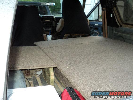 1986 Ford Bronco interior with custom carpeted platform covering the rear cargo area