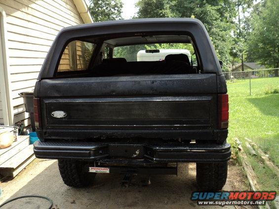 Rear view of a black Ford Bronco parked outdoors. A Mercury Marine sticker is visible on the bumper