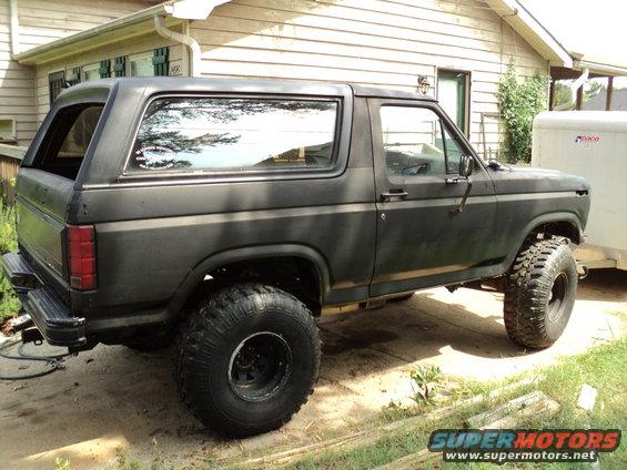 Black Ford Bronco with lifted suspension and large tires, seen from the side