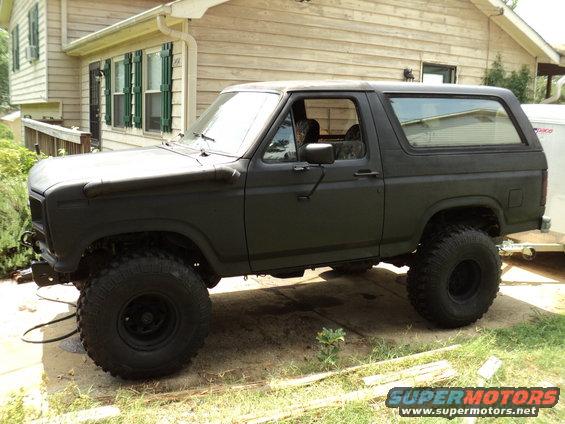 Matte black Ford Bronco with lifted suspension and large tires parked in a driveway