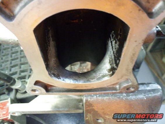 Close-up of an engine intake manifold port, showing the internal passage
