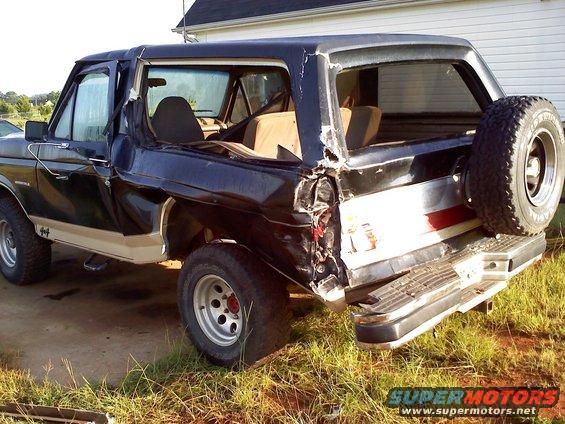 Rear view of a damaged 1989 Ford Bronco with a spare tire mounted externally
