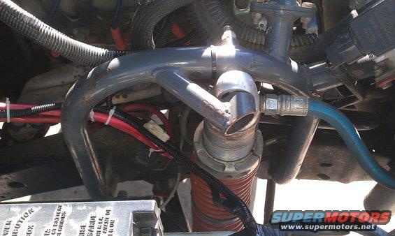Close-up of engine hoses and wiring, with a Supermotors.net watermark
