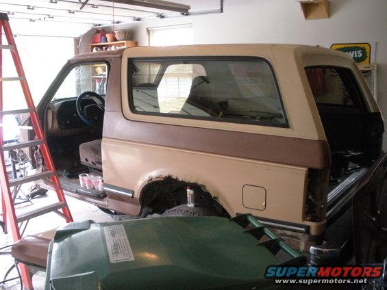 Side view of a 1987 Ford Bronco in a garage, undergoing repairs