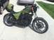 2002 Kawasaki Ninja - Motorcycle with a green helmet on the seat, parked outdoors on a concrete driveway.