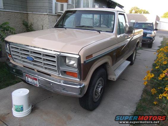 Tan and brown 1985 Ford F-250 pickup truck, 3/4 front view. Another vehicle is parked behind it