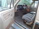 1985 Ford F-250 - The interior of a beige truck cab is shown, a blanket-covered seat and a view of the dashboard.