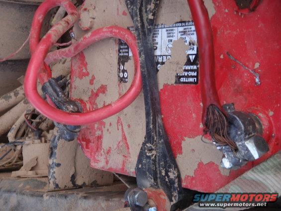 close-up of a dirty vehicle battery with red cables connected