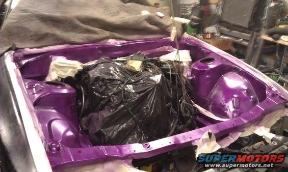 Engine bay with purple paint, covered engine, and masking tape