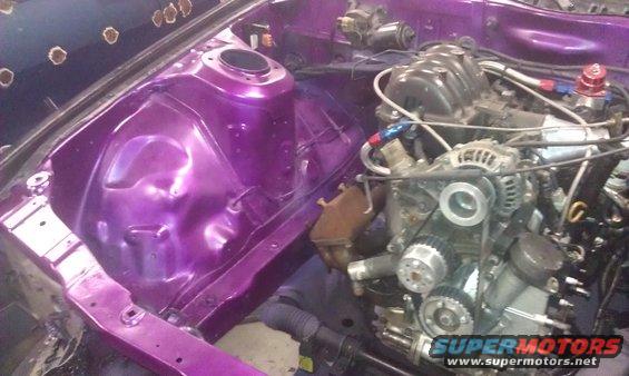 Engine bay with purple paint and a rotary engine installed. Some parts are missing